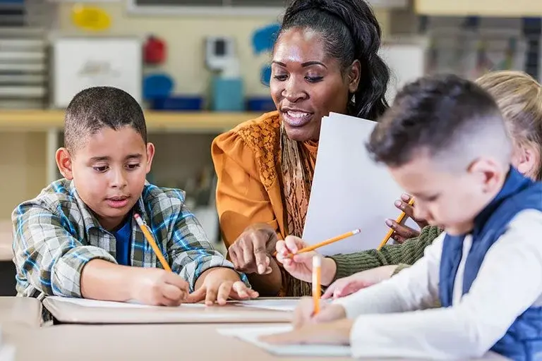 Teacher_working_with_students_paper_and_pencil